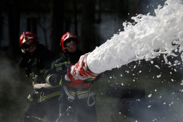 Firefighters holding a hose