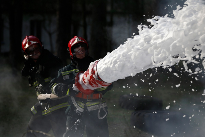 Firefighters holding a hose