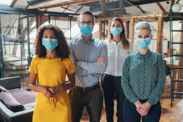 Four coworkers wearing face masks