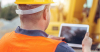 Man wearing safety gear using a laptop 