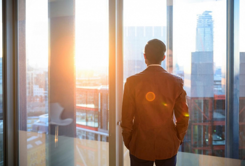 Man looking out window at city skyline